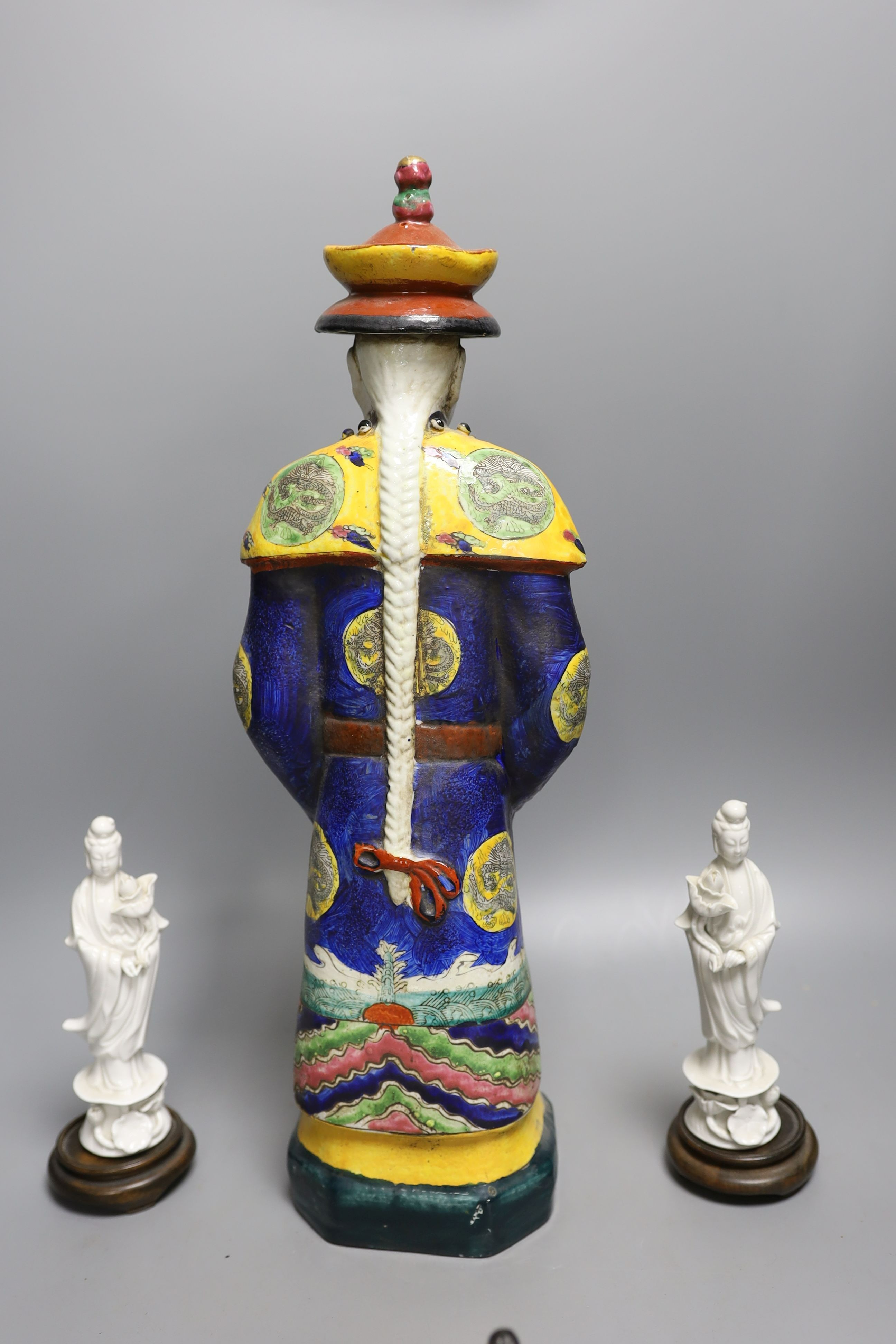 A Chinese brush pot, a pair of blanc de chine deities, a famille rose early 20th century figure, and a Kangxi emperor brush holder (5) - 45cm tall